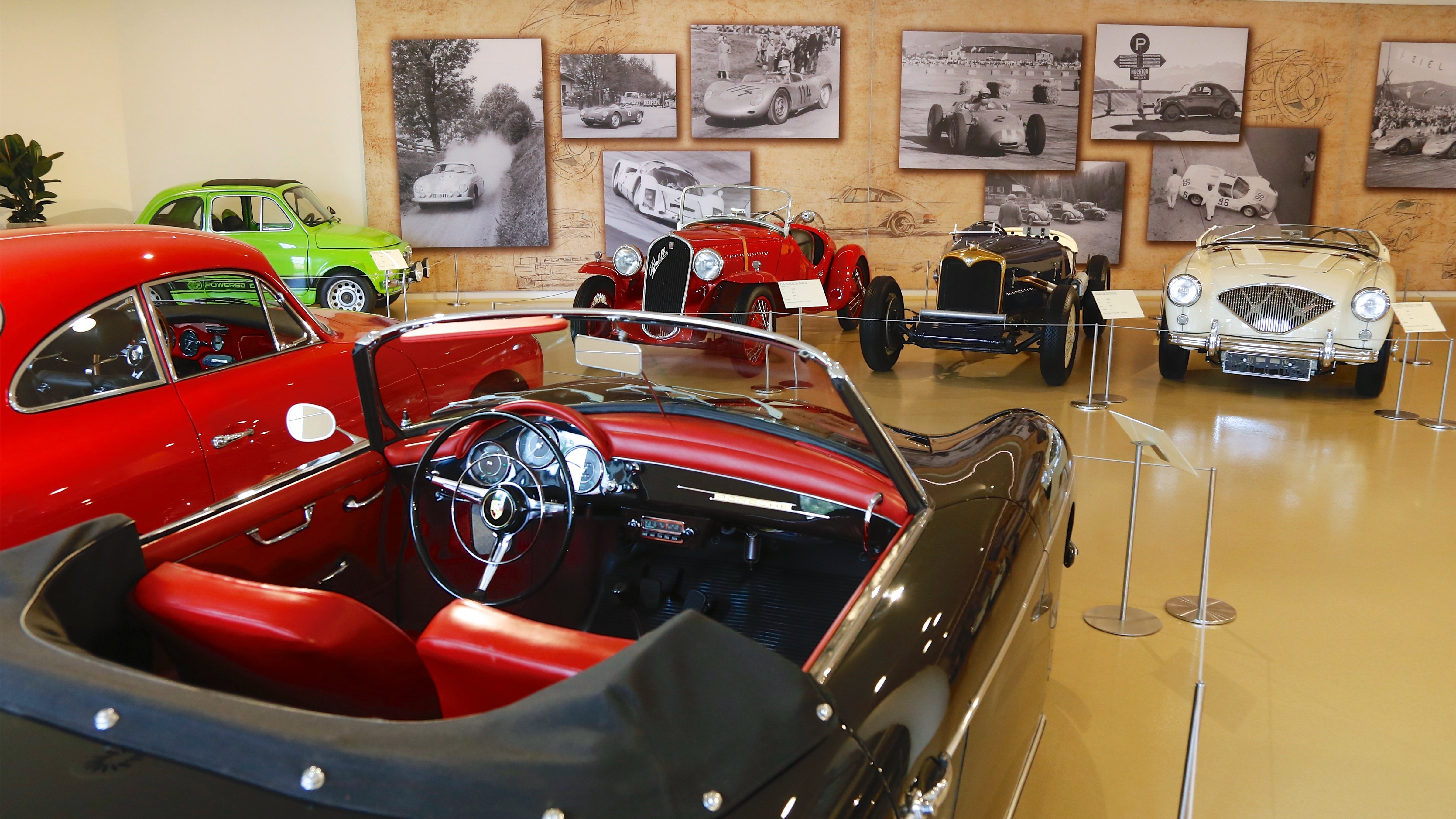 Verschiedene klassische Autos in einer Museumsausstellung, gut sichtbar angeordnet.