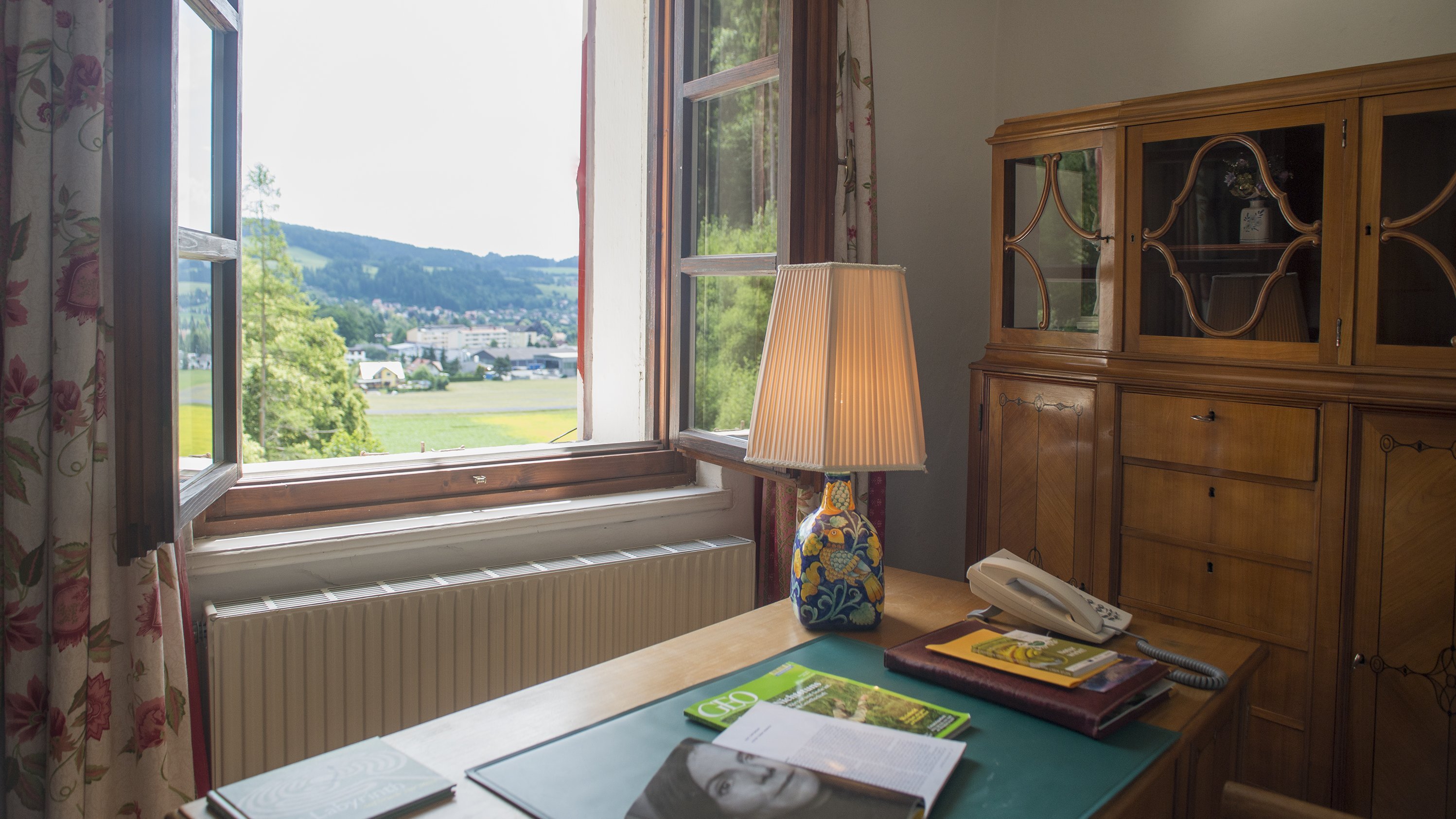 Helle Homeoffice-Oase Gemütliches Zimmer mit Schreibtisch und großem Fenster für Tageslicht und Ausblick