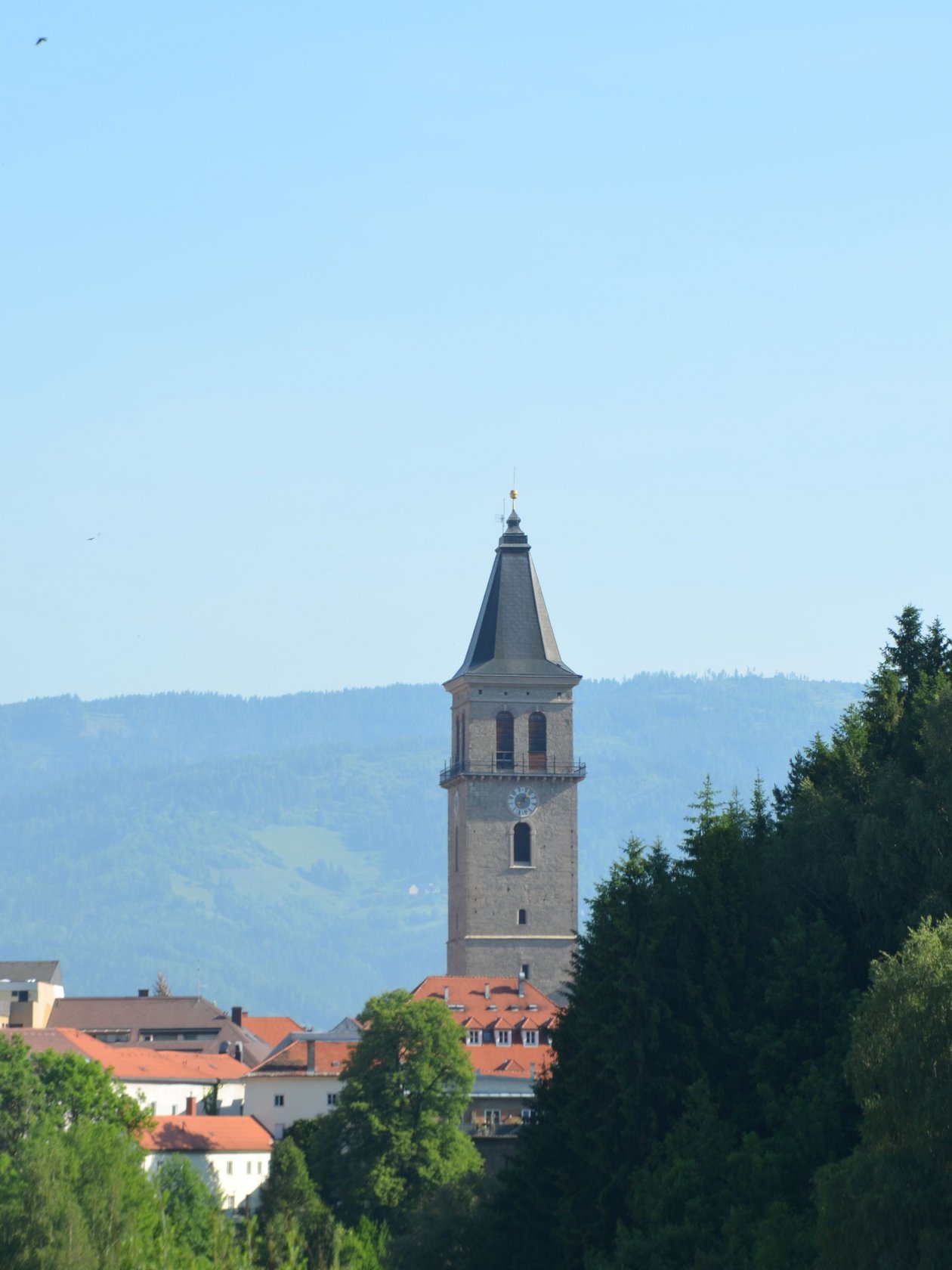 Historischer Turm in der Natur Hoher Turm umgeben von einer grünen Landschaft und Bergen im Hintergrund, historisches Gebäude