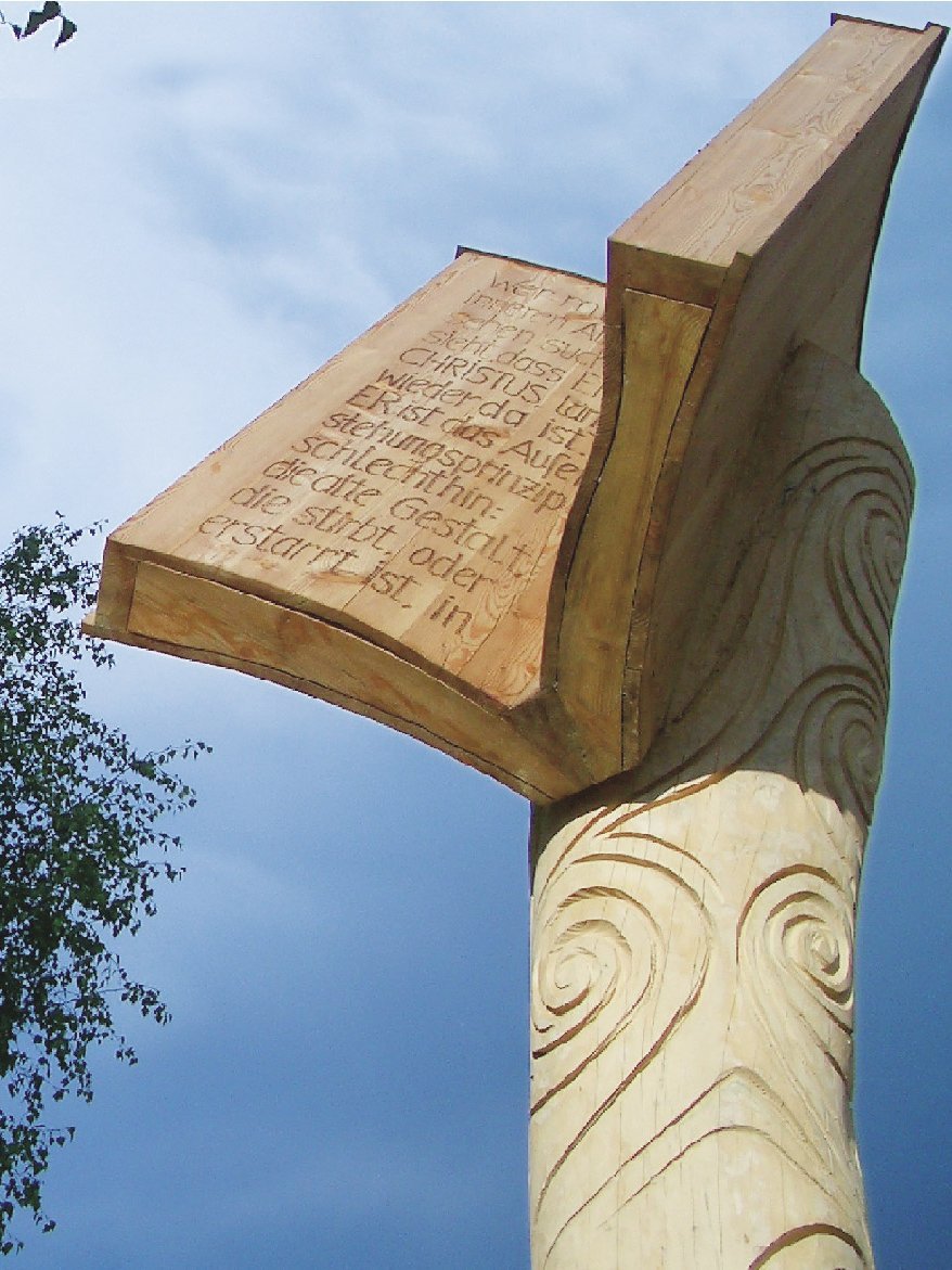 Holzskulptur im Naturpark Hohe Holzskulptur mit detaillierten Schnitzereien vor blauem Himmel als kulturelles Erbe