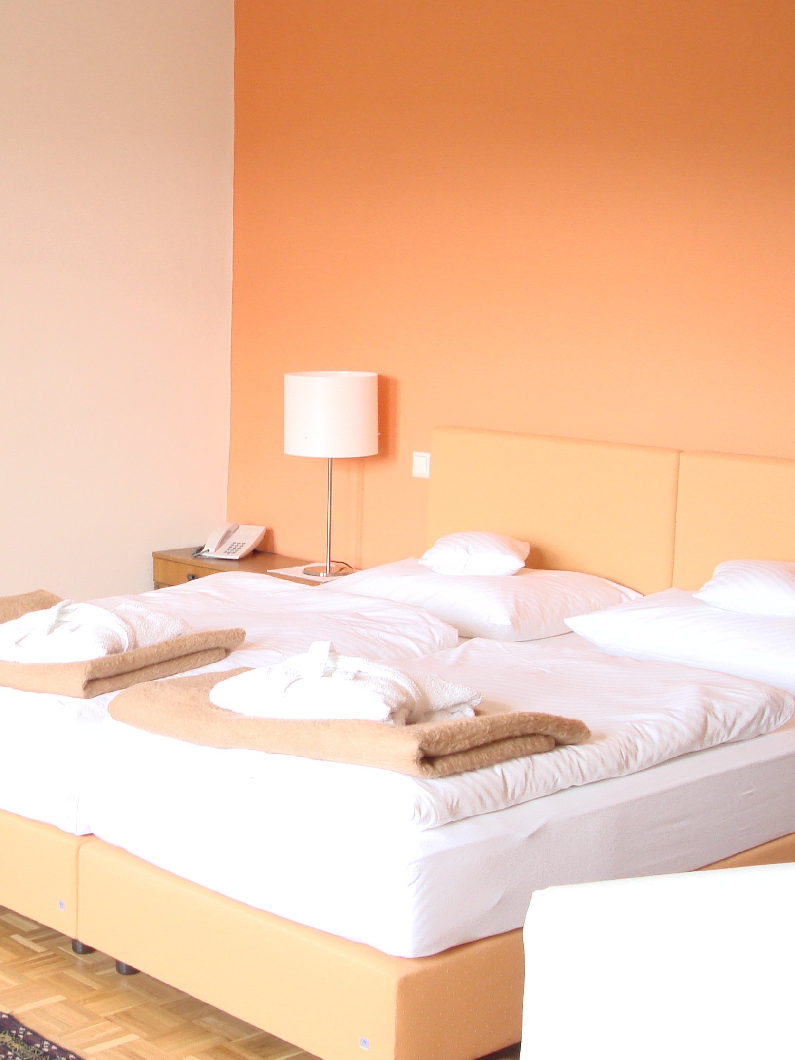 Helle Hotelzimmer mit Doppelbett, gemalter Wandkunst und gemütlicher Sitzecke im Innenbereich