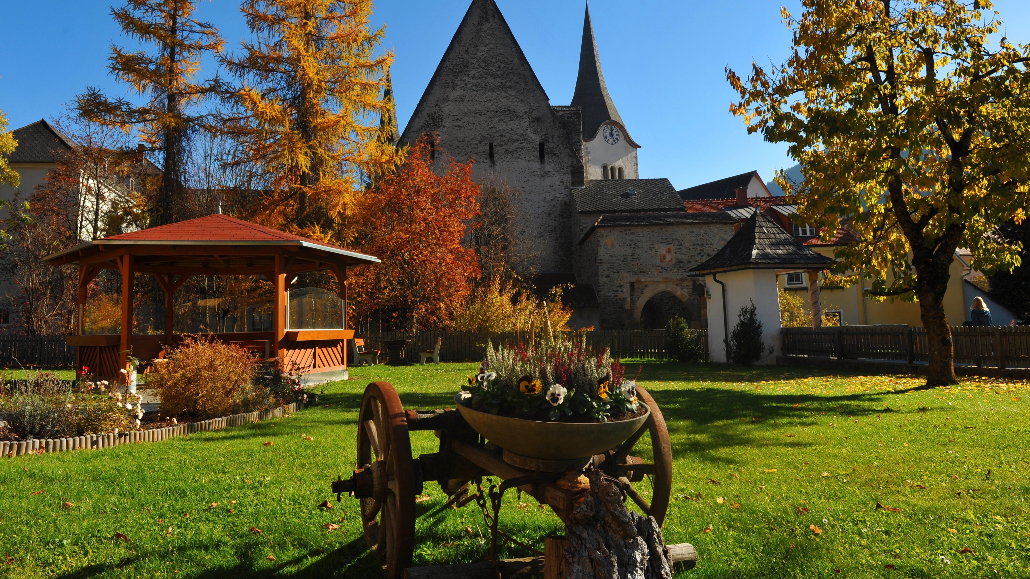 Herbstlandschaft mit historischer Kirche Herbstliche Landschaft mit einer alten Kirche und einem Gartenpavillon umgeben von buntem Laub