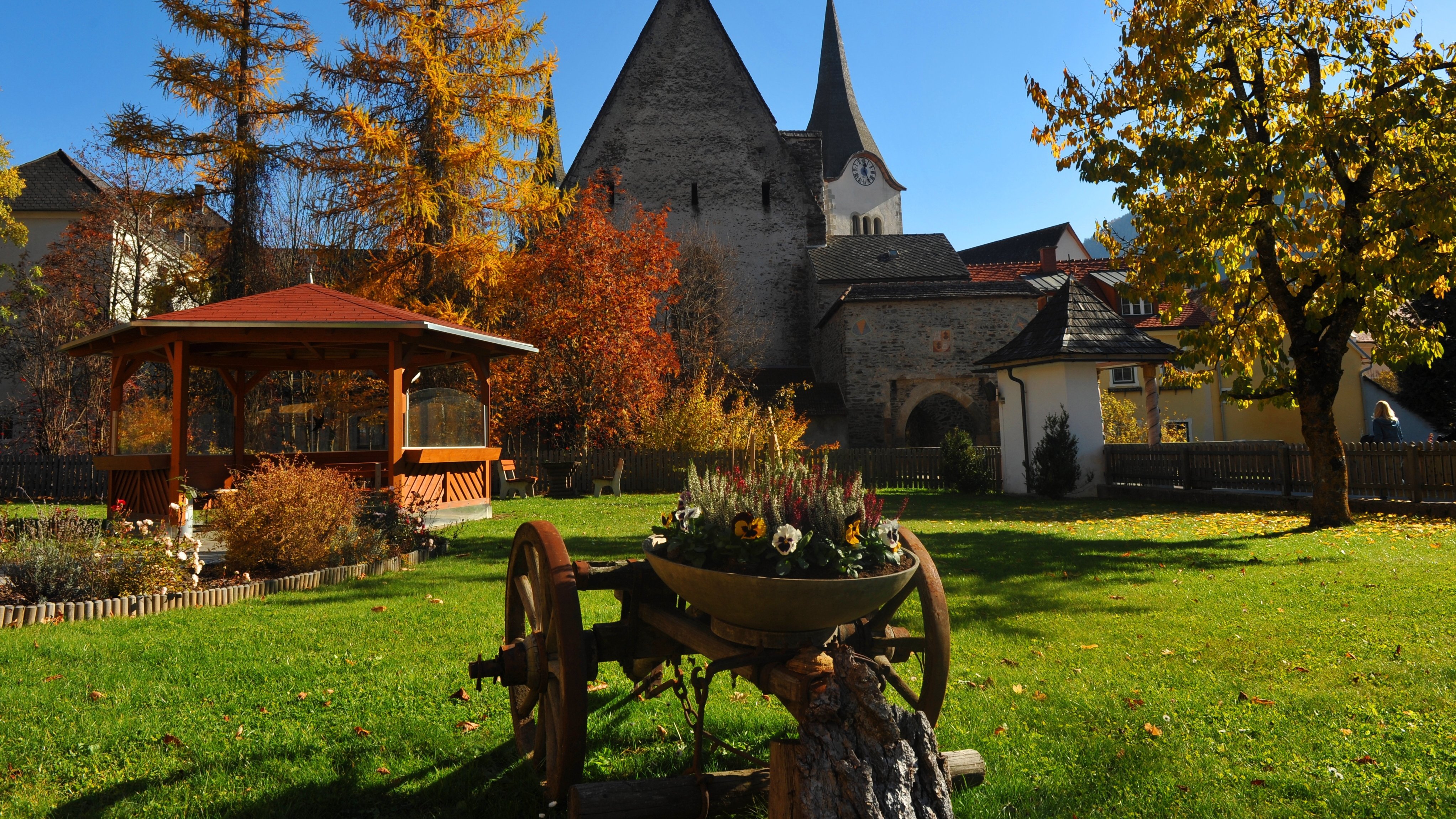 Herbstlandschaft mit historischer Kirche Herbstliche Landschaft mit einer alten Kirche und einem Gartenpavillon umgeben von buntem Laub
