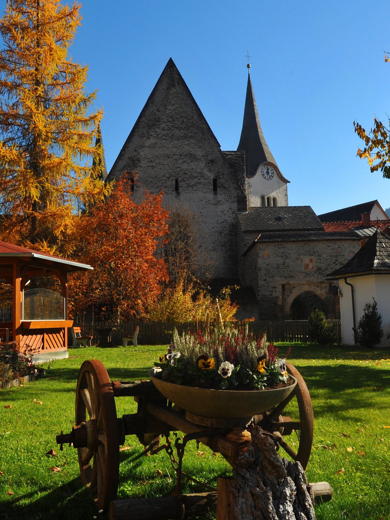 Herbstlandschaft mit historischer Kirche Herbstliche Landschaft mit einer alten Kirche und einem Gartenpavillon umgeben von buntem Laub