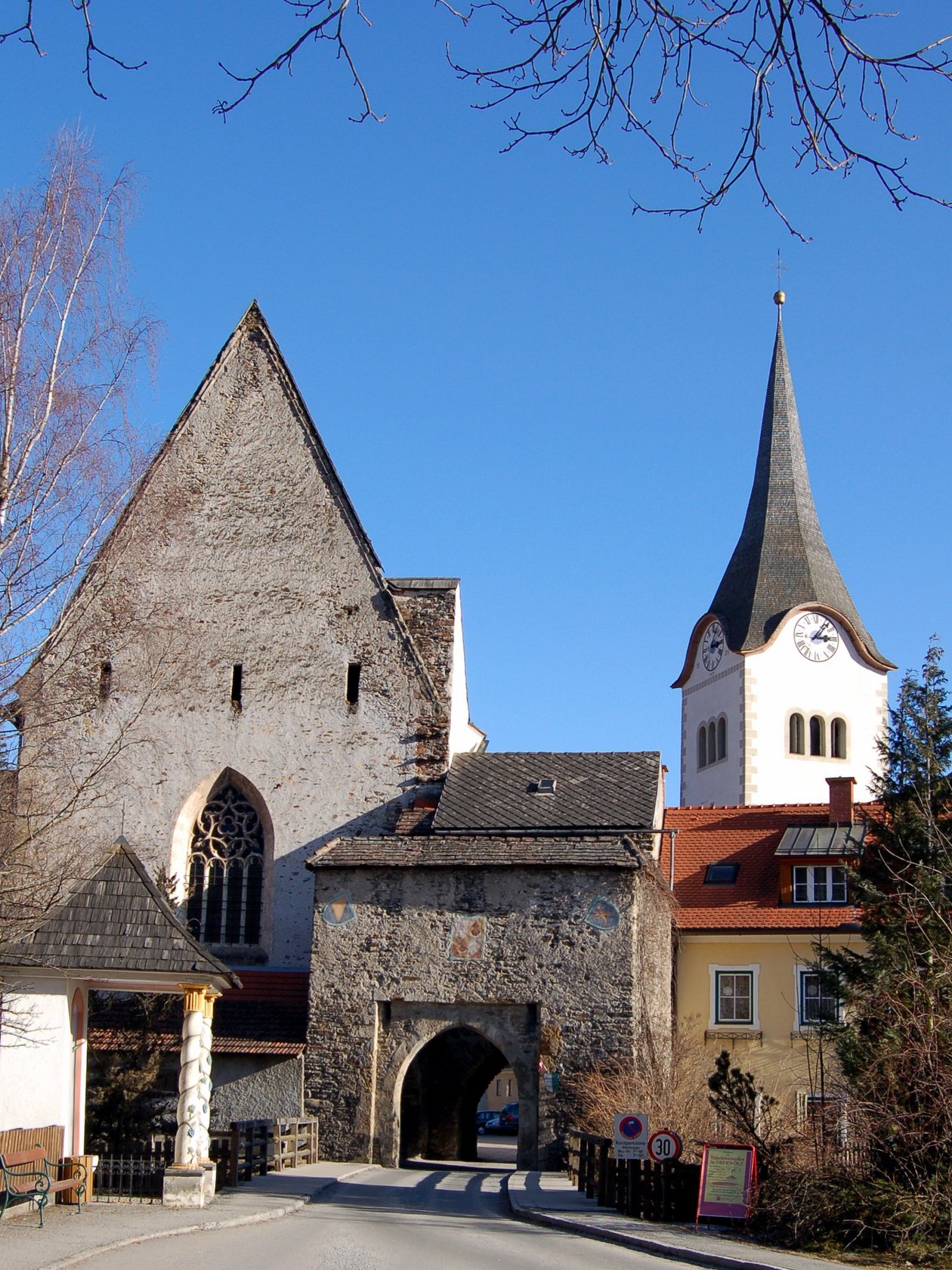 Historische Architektur und Kirchenansicht Medieval building with pointed roof and church tower against blue sky in historic town