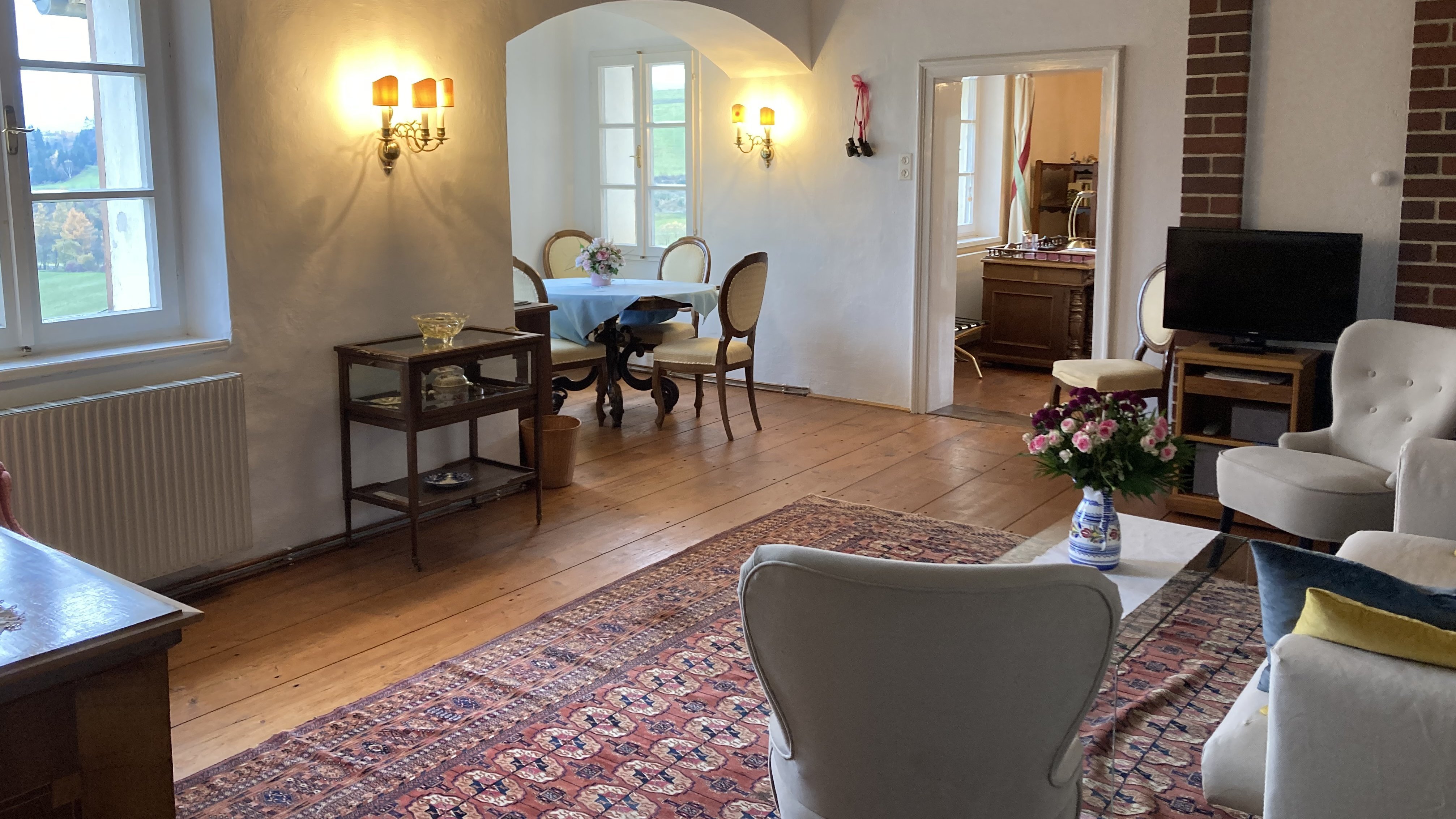 Rustikale Gemütlichkeit im Wohnzimmer Ein einladendes Wohnzimmer mit rustikalen Holzbalken und verschiedenen Möbelstücken.