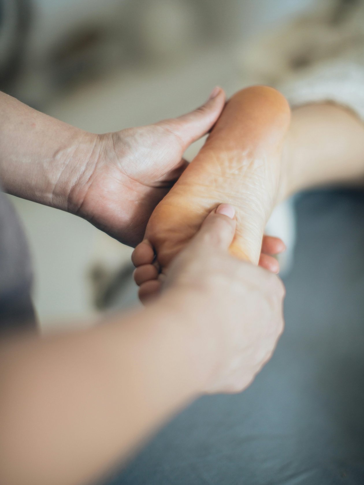 Wohlfühlmomente bei Fußmassagen Eine Hand übt Druck auf die Sohle eines Fußes während einer Massage aus, die Entspannung fördert.