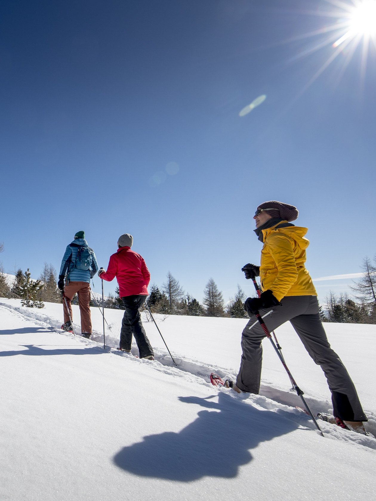 Schneeschuh-Abenteuer am Zirbitzkogel Drei Personen beim Schneeschuhwandern in einer verschneiten Landschaft unter blauem Himmel.