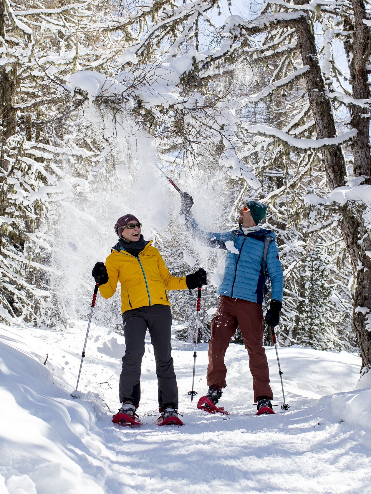 Schneeschuhabenteuer am Zirbitzkogel Zwei Personen beim Schneeschuhwandern in einem verschneiten Wald, Schnee wird in die Luft geworfen