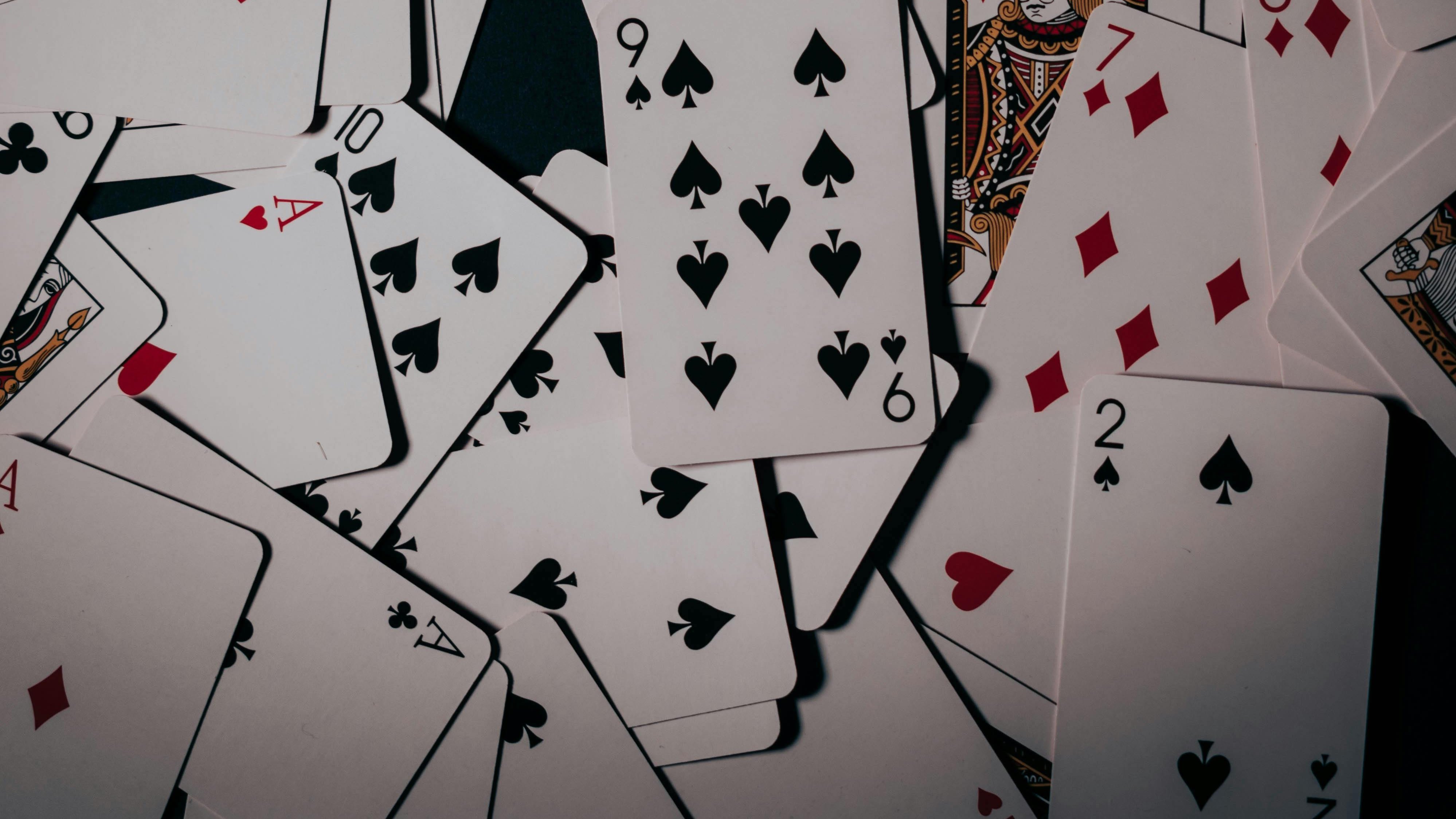 Spieleabend mit Kartenspaß Ein Haufen von Spielkarten mit verschiedenen Farben und Zahlen auf einem Tisch verteilt