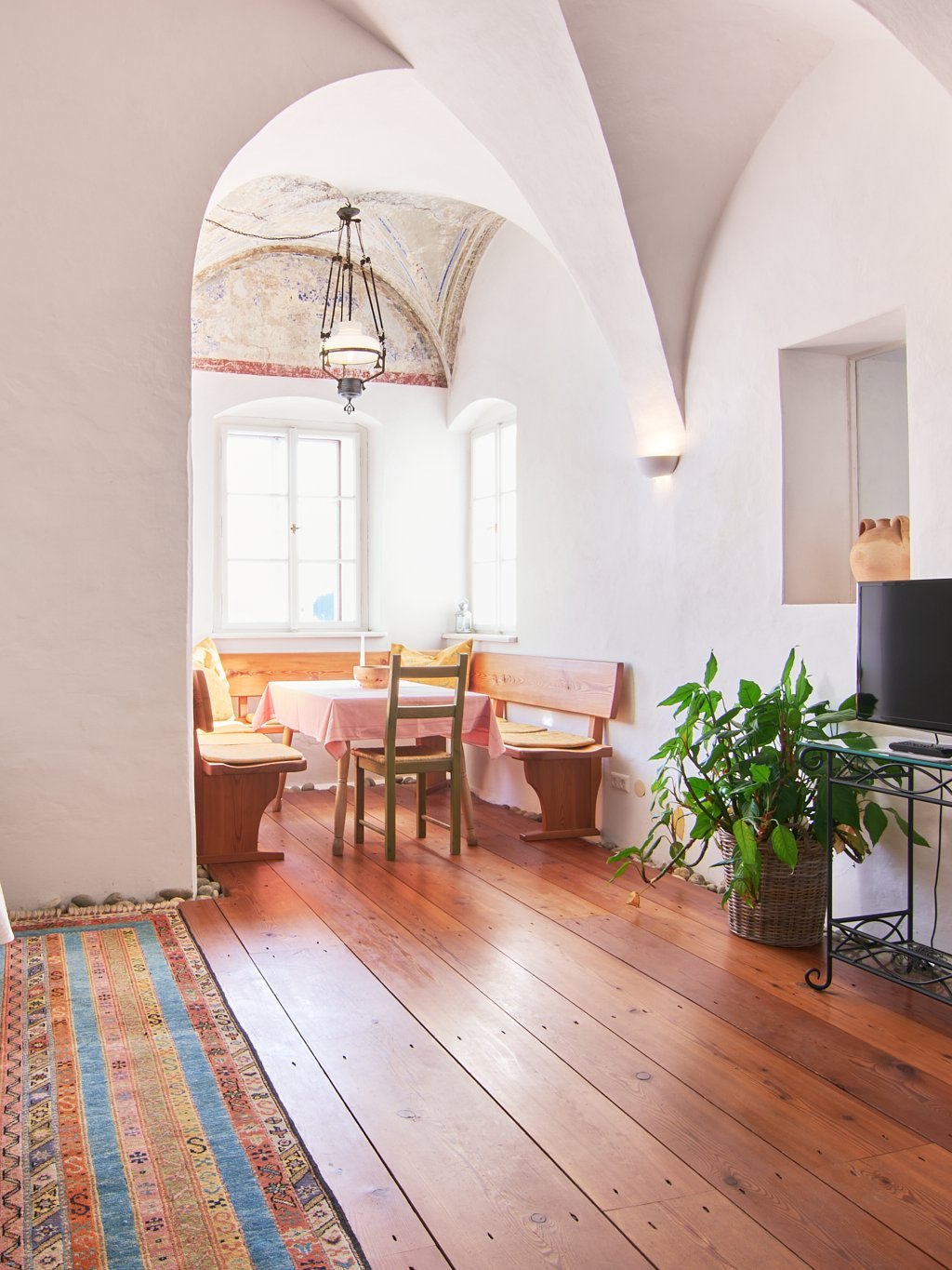 Gemütliches Wohnzimmer mit gewölbten Decken und Holzfußboden sowie Sitzmöglichkeiten