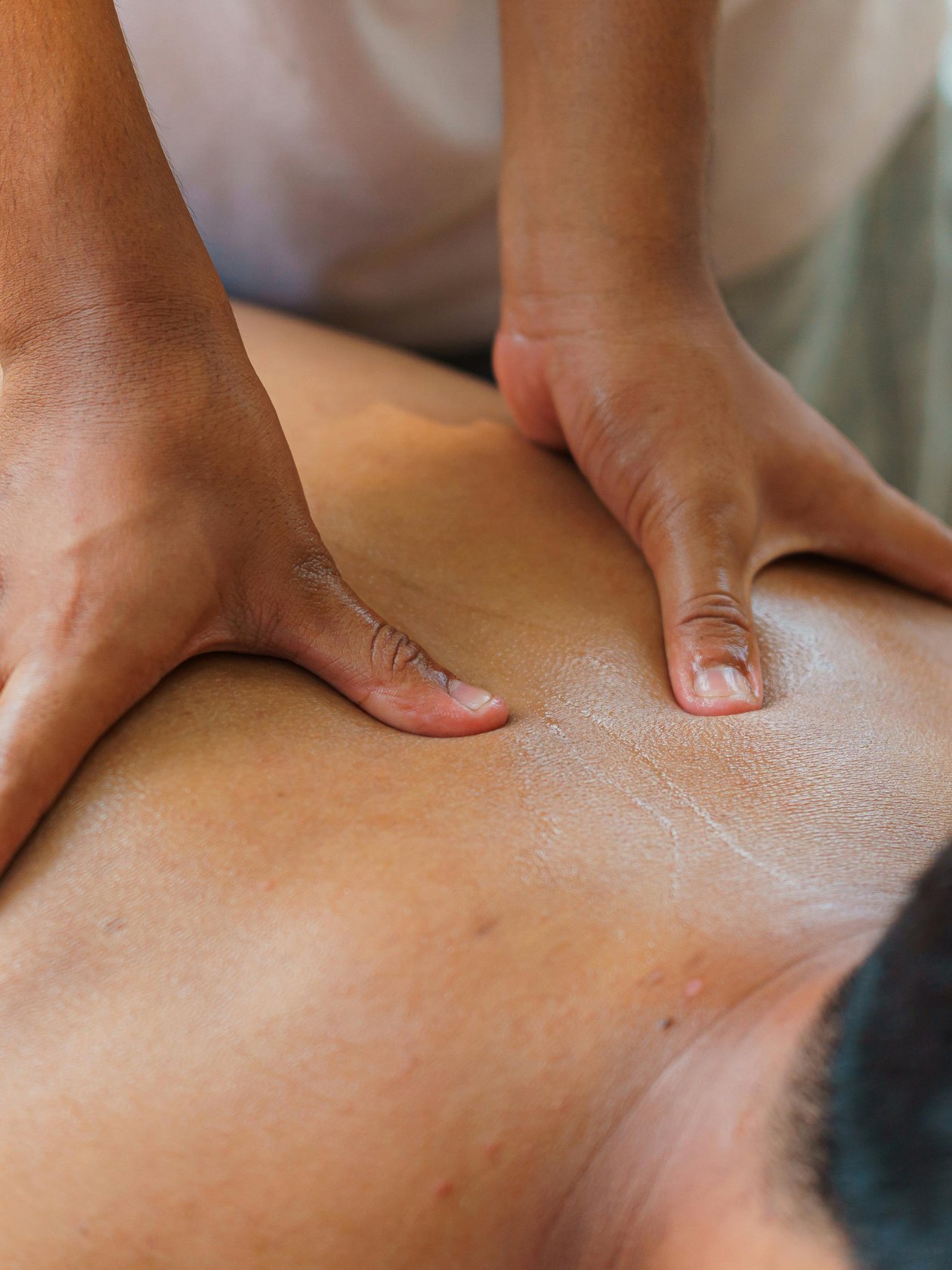 Wohlfühlmomente bei Massagen Eine Person erhält eine Rückenmassage durch Hände, die Druck ausüben, in einem ruhigen Raum.