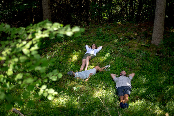 Personen liegen direkt auf dem Waldboden